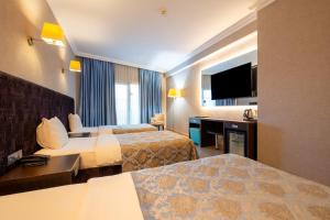 a hotel room with two beds and a flat screen tv at 216 Castle Hotel in Gebze +63 photos