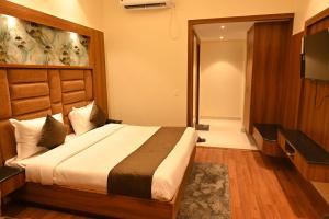 a hotel room with a bed and a television at Hotel Sahil Suites in Katra