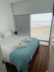 a bedroom with a bed with two trays on it at Casa dos Coelhos in Moledo