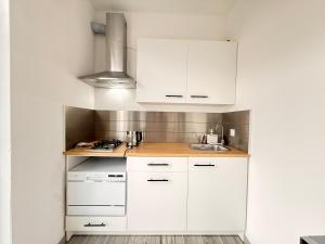 a kitchen with white cabinets and a sink at Casa Buda 1BR Apartment - Lakes Malpensa MXP 24h Check-in Parking in Sesto Calende