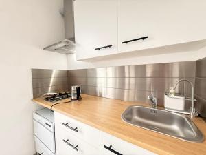 a kitchen with white cabinets and a sink at Casa Buda 1BR Apartment - Lakes Malpensa MXP 24h Check-in Parking in Sesto Calende