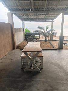 a picnic table under a pavilion with a view of the beach at Ocean beach in Galle