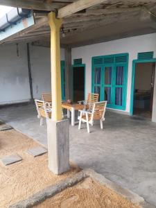 a patio with chairs and a table in a building at Ocean beach in Galle +1 photo