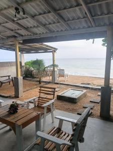 a picnic table and chairs on the beach at Ocean beach in Galle