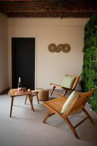 a living room with two chairs and a table at La Ferme de la Gloriette - Gîte & Spa in Émines