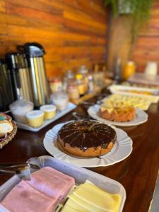 a table with a chocolate cake on plates on it at Pousada Maia in Itaúnas +17 photos