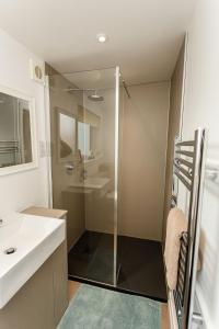 a bathroom with a glass shower and a sink at Beth's Bothy in Gatehouse of Fleet