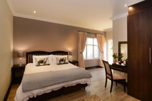a bedroom with a bed and a desk and a window at Sandown Guest House in Johannesburg +48 photos