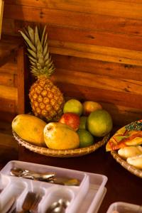 a table with two baskets of fruit on it at Pousada Maia in Itaúnas