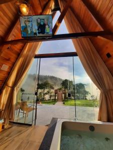 a room with a large window and a tub at Chalé Fusinato in Witmarsum