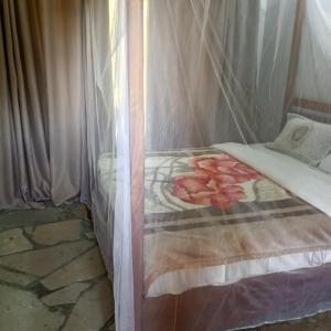 a bedroom with a bed with a canopy at cyuza paradise island in Nyarugina