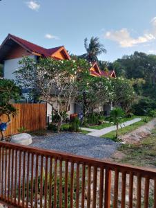 a house with a fence in front of it at Book Lanta House in Ban Ru Yai