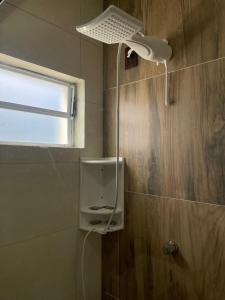 a bathroom with a shower with a light and a window at Chalé Fusinato in Witmarsum +25 photos