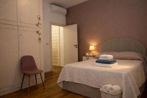 a bedroom with a bed with a chair and a door at Corina's Place Bologna Home in Bologna