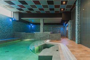a swimming pool in a building with blue lights at Hotel Spa Villa Pasiega in Hoznayo