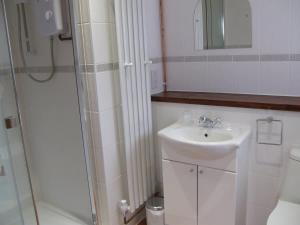 a white bathroom with a sink and a shower at Millbrook House Apartments 8 in Milton +14 photos