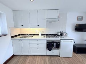 a kitchen with white cabinets and a stove top oven at Millbrook House Apartments 9 in Milton