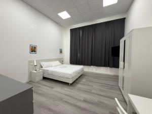 a white room with a bed and a television at Viva Residence in Calderara di Reno