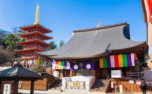 a building with a large roof with a clock on it at Comfort Villa Takahata in Takahate