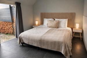a bedroom with a bed with two night stands and a window at De Kasteelboerderij in Ruurlo +65 photos