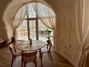 a room with a table and chairs and a window at Kupolinis namelis in Kilova II