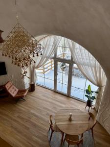 a living room with a table and a large window at Kupolinis namelis in Kilova II