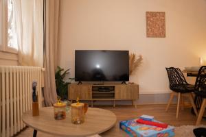 a living room with a flat screen tv on a table at L'Élégance - Cozy & Parking in Chambéry