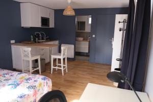 a kitchen and a living room with a table and chairs at Beau studio calme, indépendant avec terrasse in Pessac