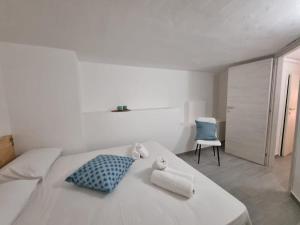 a white bedroom with a bed and a chair at Tortuga Smeralda in Porto Rotondo +5 photos