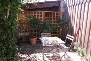 a patio with a table and chairs in front of a fence at Beau studio calme, indépendant avec terrasse in Pessac