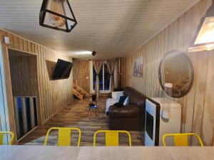 a living room with a couch and a table and yellow chairs at Loft playaBlanca in Coronel