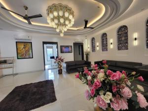 a large living room with a chandelier and pink flowers at Jhansi Hotel in Jhānsi
