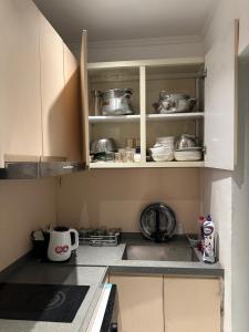 a kitchen with white cabinets with pots and pans at شقة رقم 1 in An Najaf