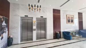 a lobby with two elevators and a table and chairs at Eid Holiday in Muscat