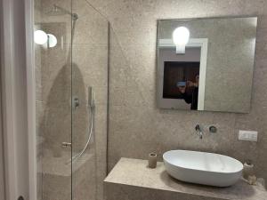 a person taking a picture of a bathroom with a sink and shower at Masseria Brigarè in Cassano delle Murge +11 photos