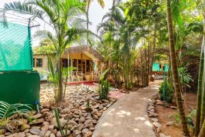 a house with palm trees in front of a yard at Sea Shades Cottages with Private Jacuzzi in Palolem