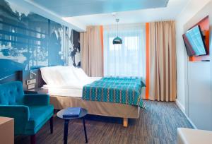 a hotel room with a bed and a chair at Solo Sokos Hotel Lahden Seurahuone in Lahti