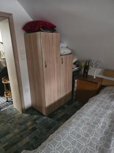 a bedroom with a wooden cabinet next to a bed at Ubytování Rumberk 2 in Deštná