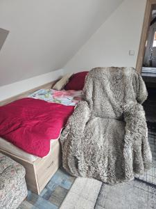 a bedroom with a bed and a chair with a blanket at Ubytování Rumberk 2 in Deštná