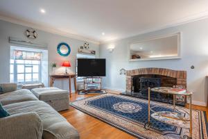 a living room with a fireplace and a tv at Stoneywell Cottage - Elie in Elie