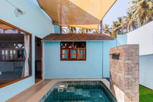 a house with a swimming pool next to a building at Sea Shades Cottages with Private Jacuzzi in Palolem