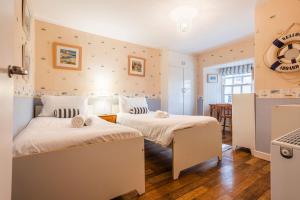 a bedroom with two beds and a kitchen at Stoneywell Cottage - Elie in Elie