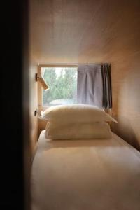 a bed with pillows and a window in a room at L YOUNG Inn Capsule Hotel Myeongdong in Seoul