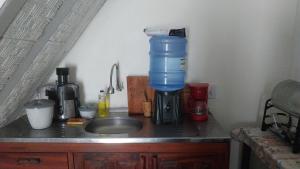 a kitchen counter with a mixer and a sink at Casa para alugar in Paraty