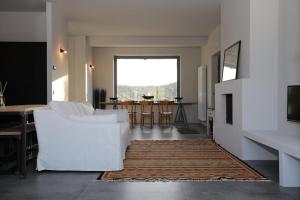 ein Wohnzimmer mit einem weißen Sofa und einem Tisch in der Unterkunft C A S A A D E L E per una vacanza in semplicità e relax in Itri