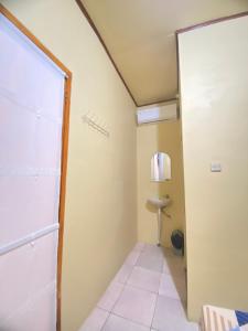 a small room with a door to a bathroom at Sadewa homestay batukaras in Batukaras +36 photos