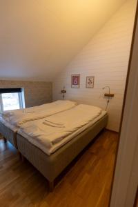 a bedroom with a large bed in a attic at Annexet Hjälmareds mill in Alingsås