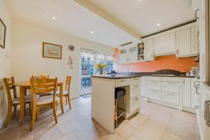 a kitchen with a table and a dining room at The Sweet Spot in Ickenham