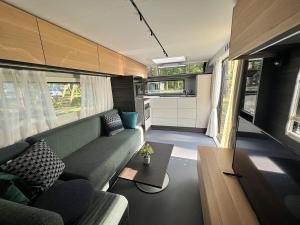 a living room with a couch and a table at Ferienhäuser Insel Usedom - Luxuswohnwagen Doppeltür mit Whirlpool in Lütow +15 photos
