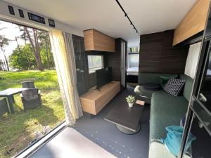 a small caravan with a living room and a tv at Ferienhäuser Insel Usedom - Luxuswohnwagen Doppeltür mit Whirlpool in Lütow